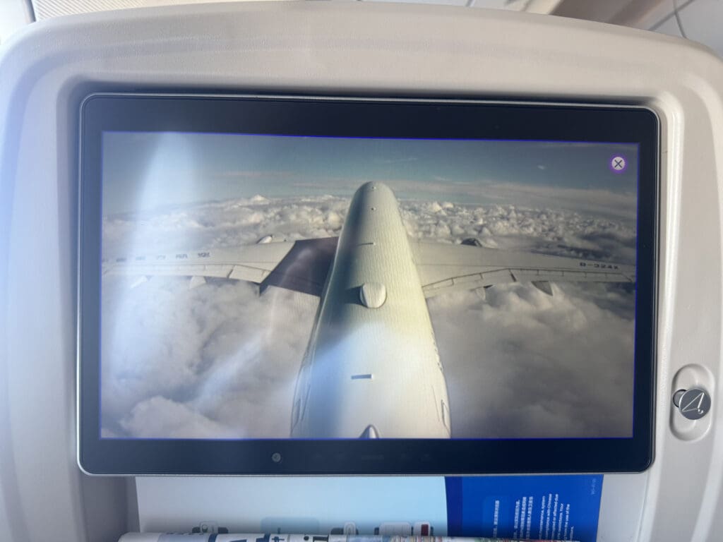 a screen with a plane wing in the sky