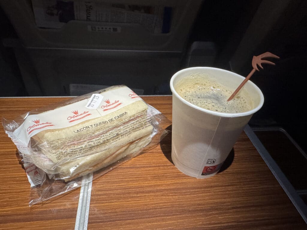 a cup of coffee and a sandwich on a table