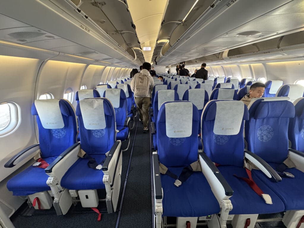 a plane with blue seats and people in the back