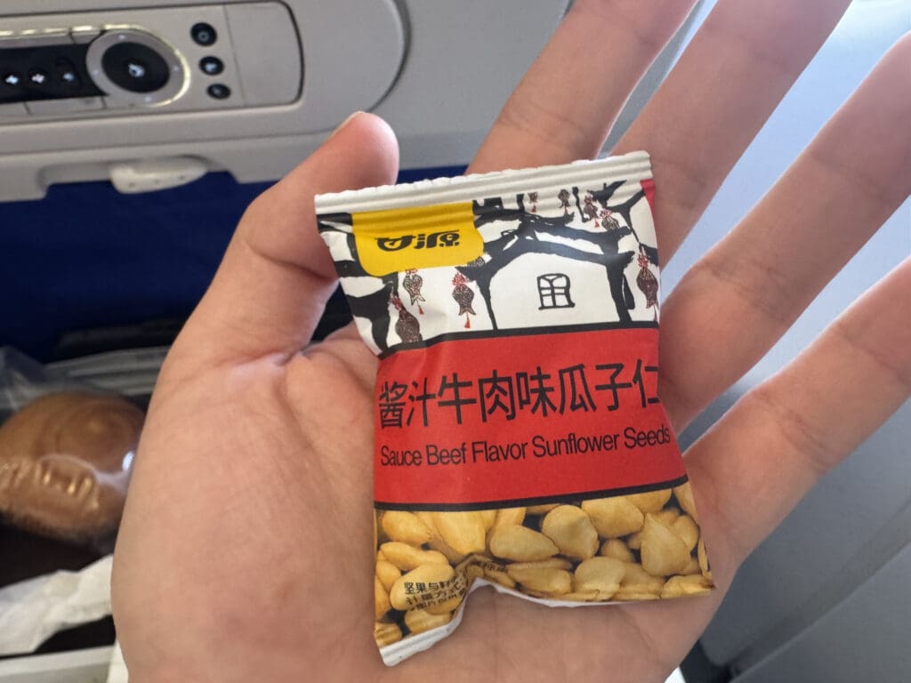 a hand holding a small packet of sunflower seeds