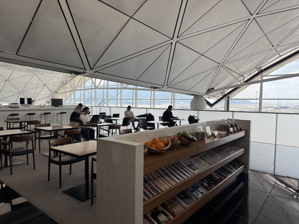 people sitting at tables in a room with a glass ceiling
