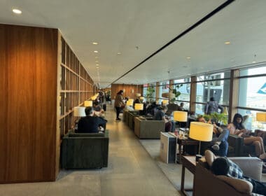 a group of people sitting in a room with tables and chairs