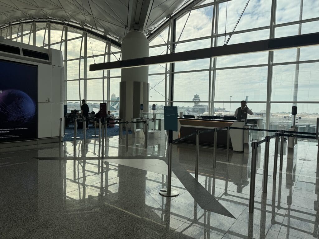 a man standing behind a counter in a large glass building