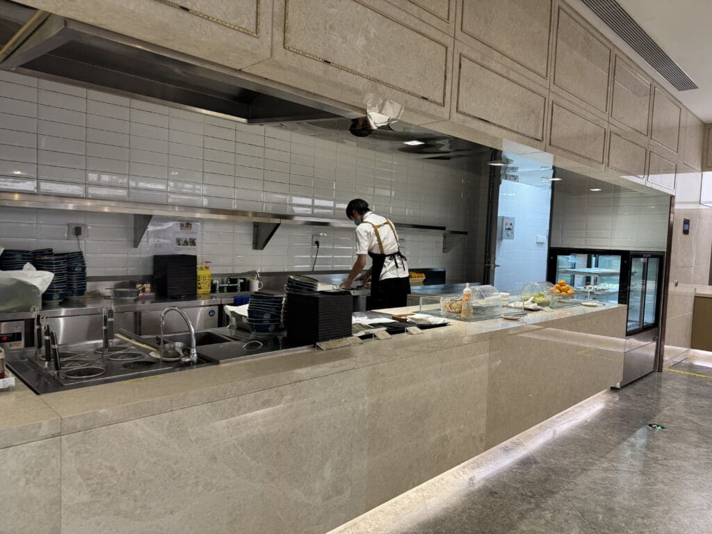 a man in a white apron standing in a kitchen
