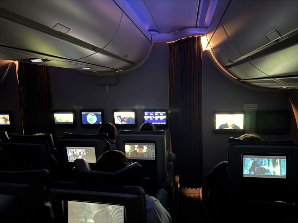 a group of people sitting in chairs with televisions on the wall
