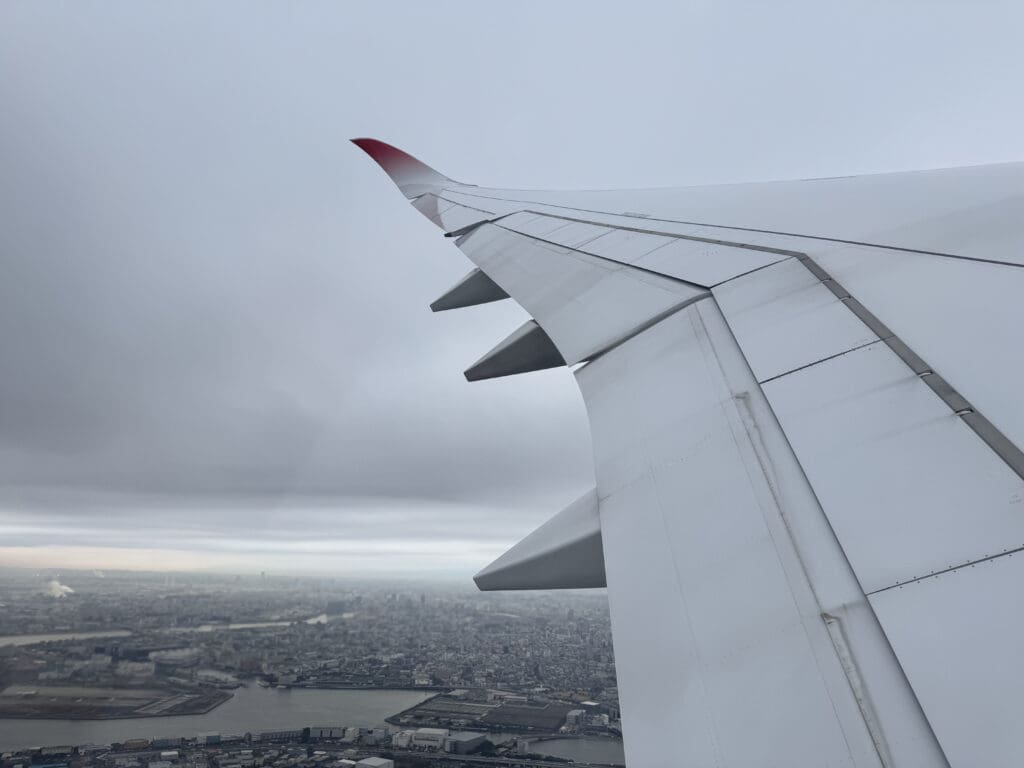the wing of an airplane flying over a city