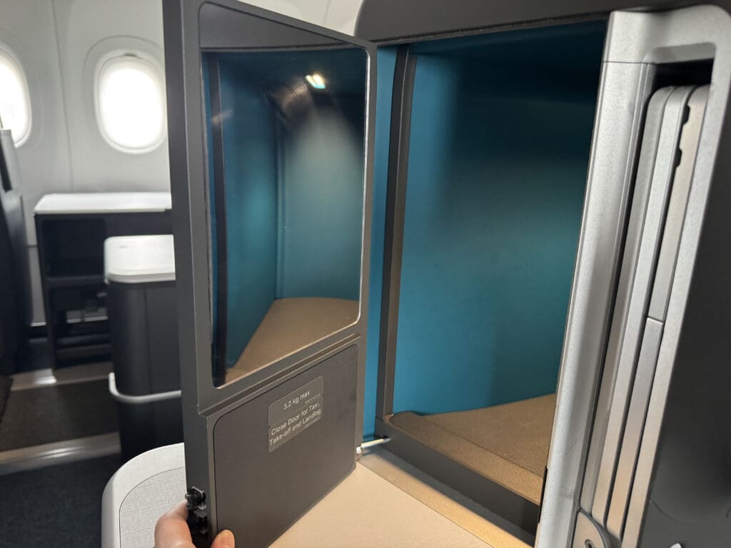 a hand holding a small mirror in an airplane