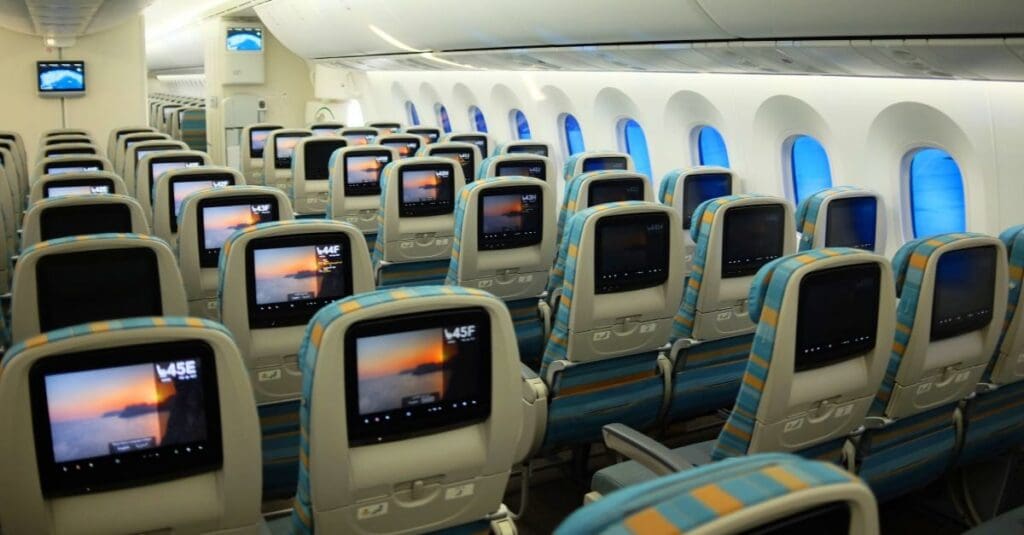a row of seats with monitors on the seats