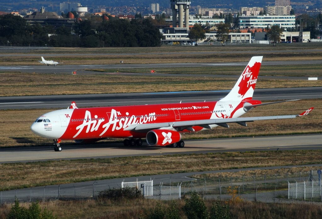 a red and white airplane on a runway