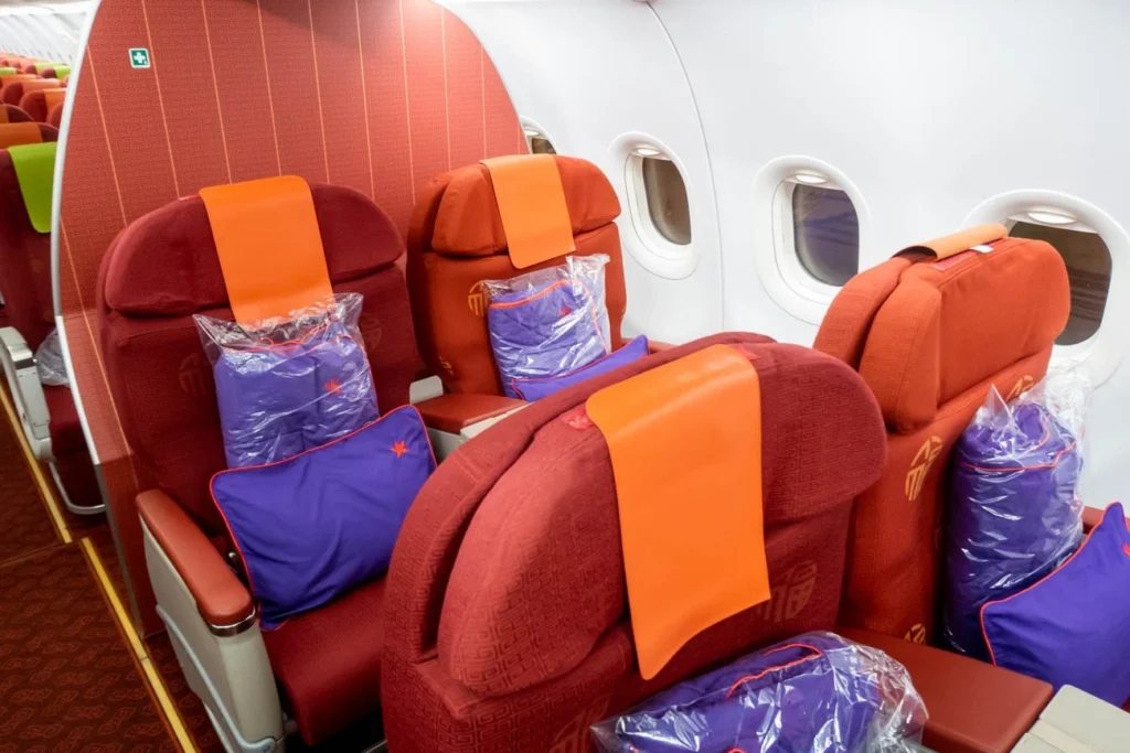 a row of red and orange seats in an airplane