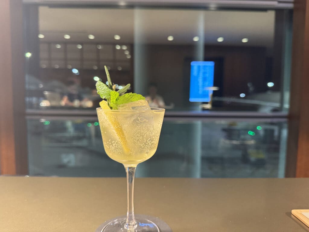 a glass with a drink and a leafy drink on a table
