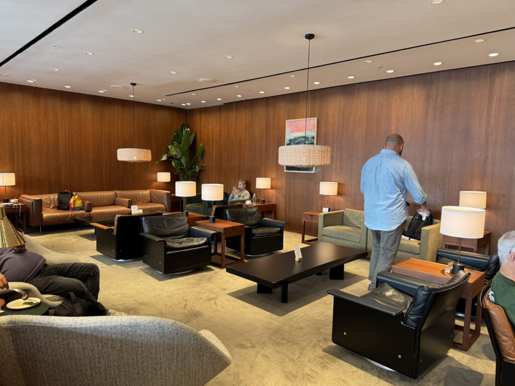 a man standing in a room with a couch and chairs