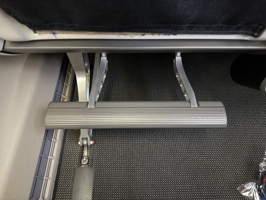 a metal foot rest under a gym machine