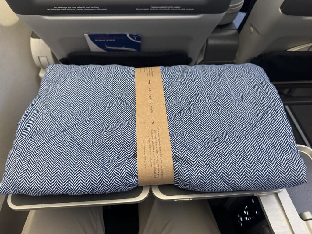 a blue and white blanket on an airplane seat