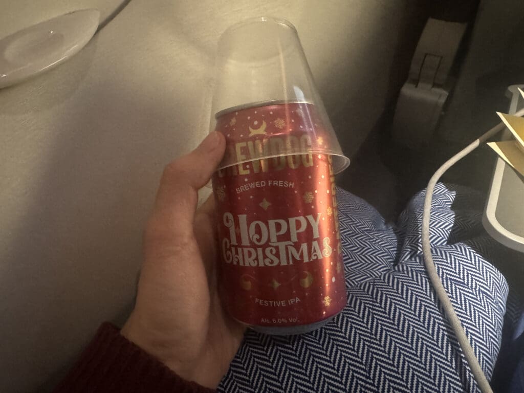 a hand holding a red can with a clear lid