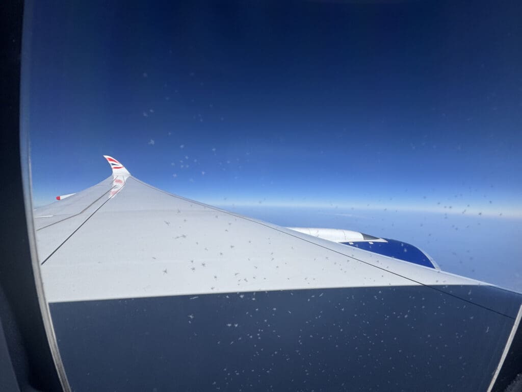 an airplane wing with a blue sky and clouds