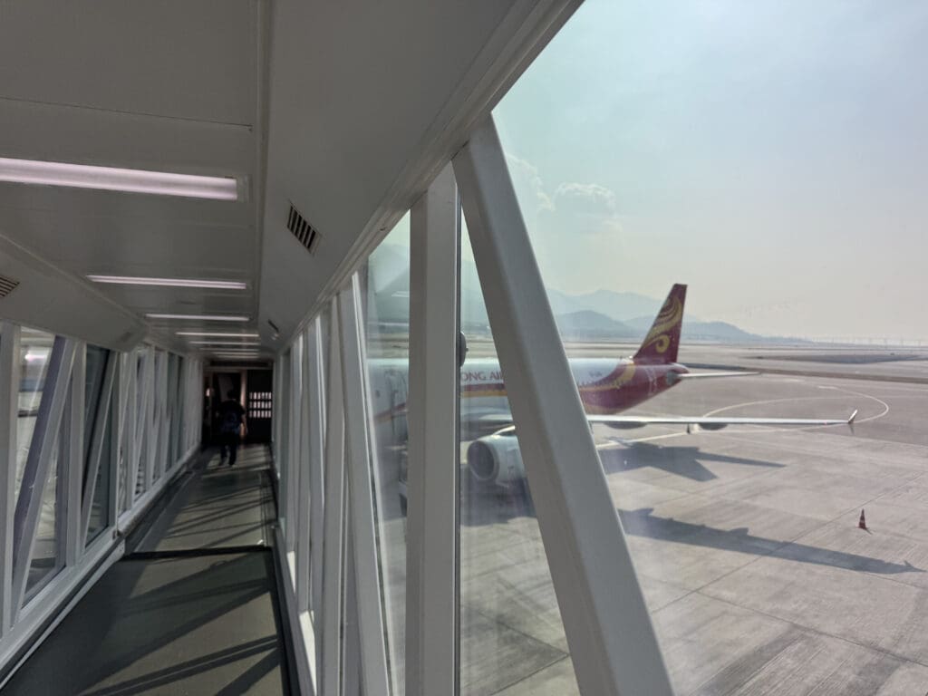 a hallway with windows and a plane on the ground