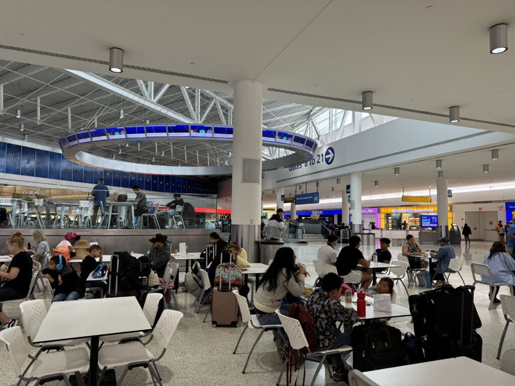 people sitting at tables in a large airport