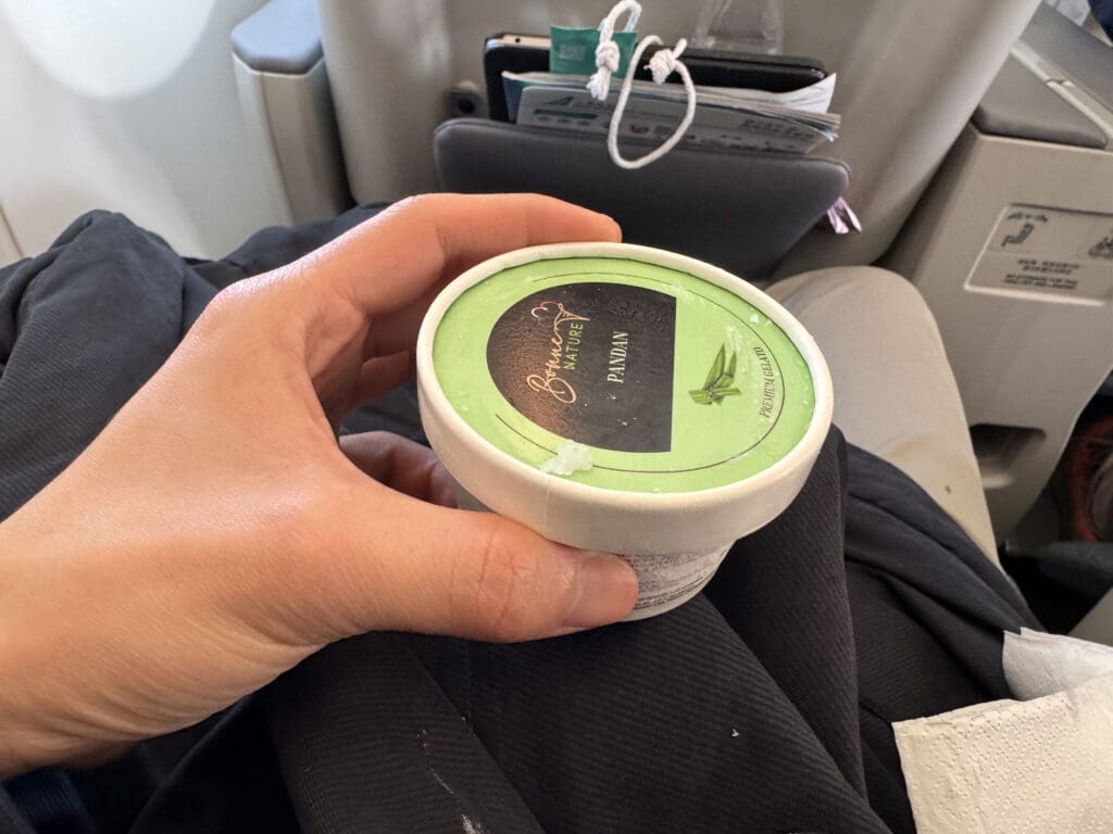 a hand holding a container of ice cream