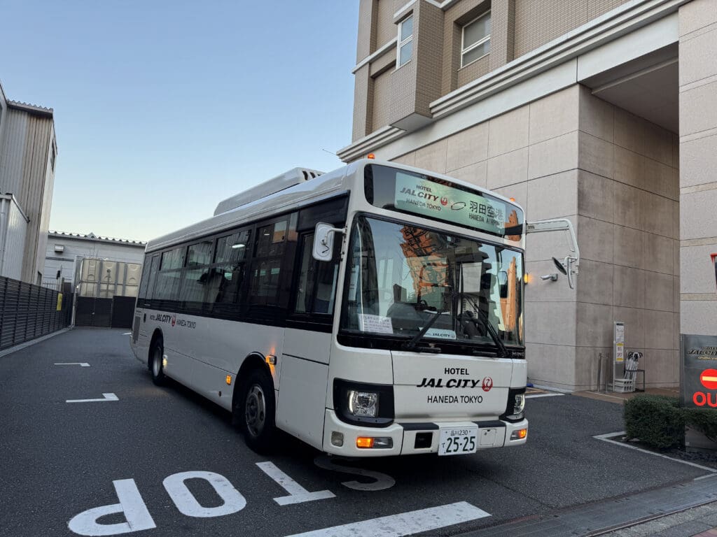 a white bus parked in front of a building