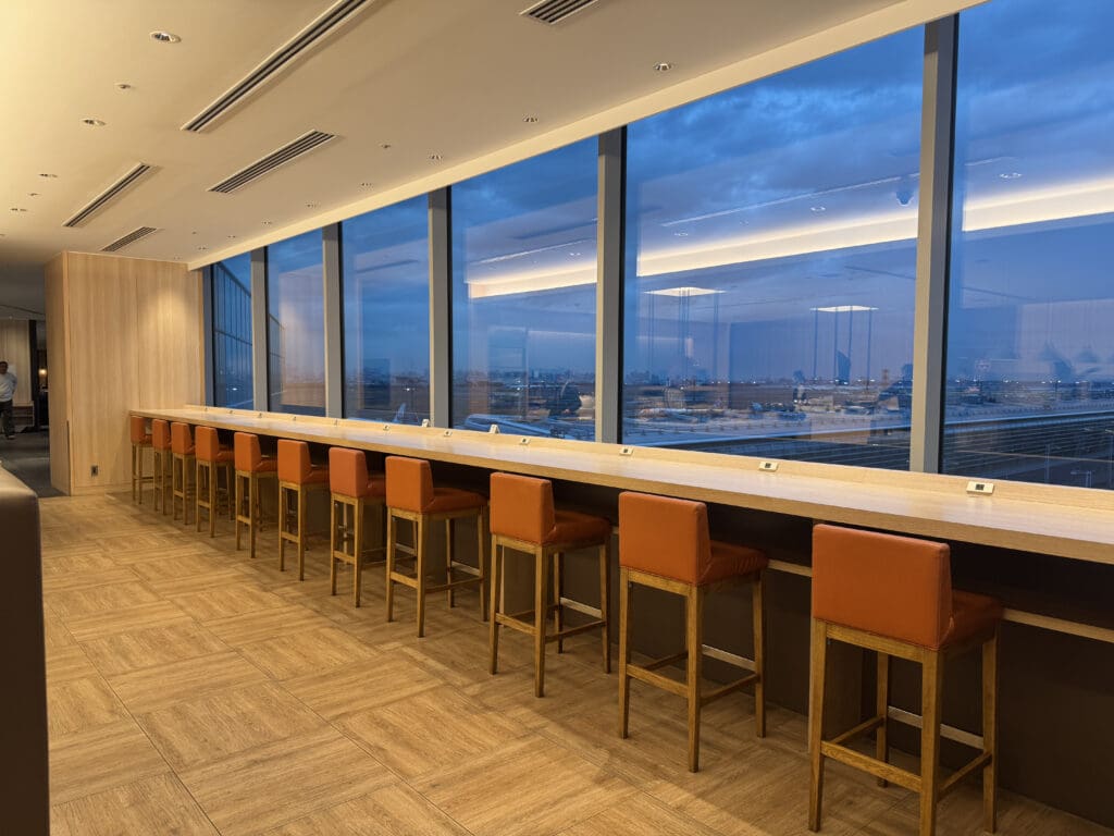 a long bar with chairs in a room with windows