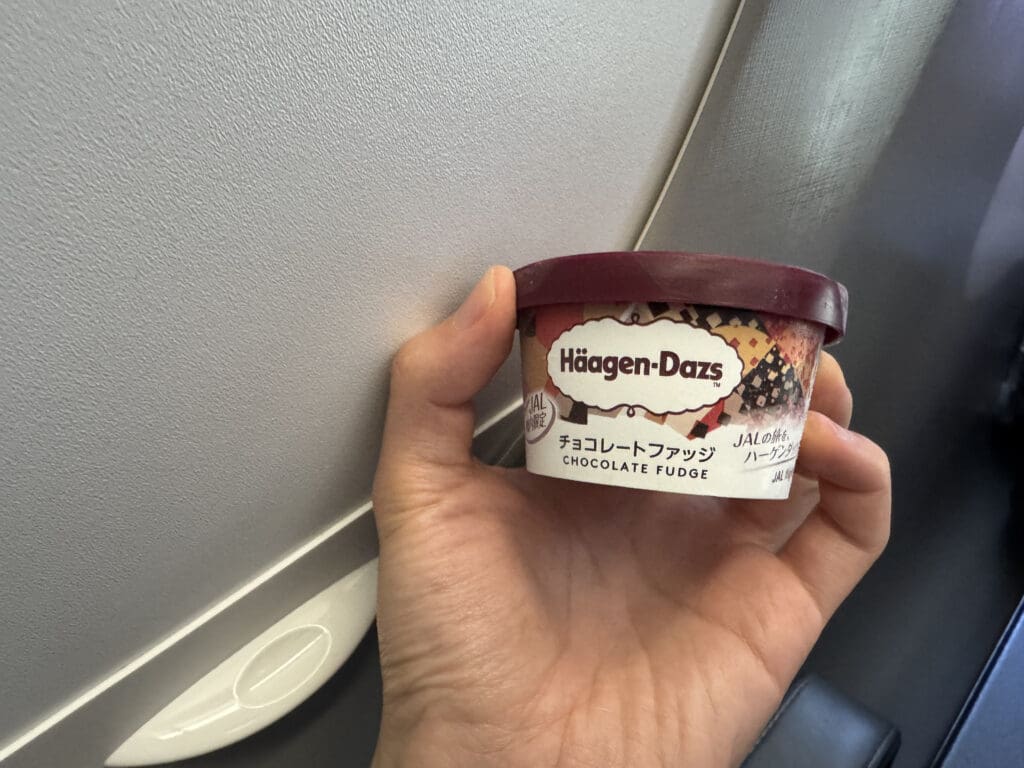 a hand holding a container of ice cream