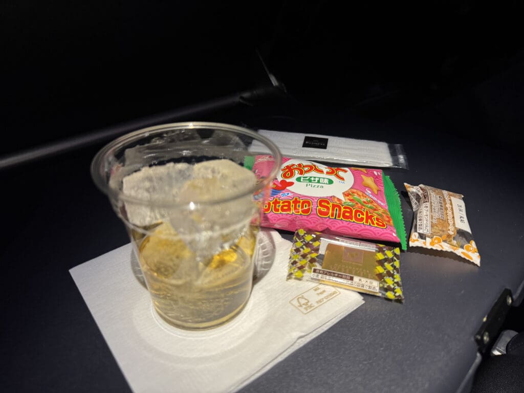 a glass of liquid and candy on a table