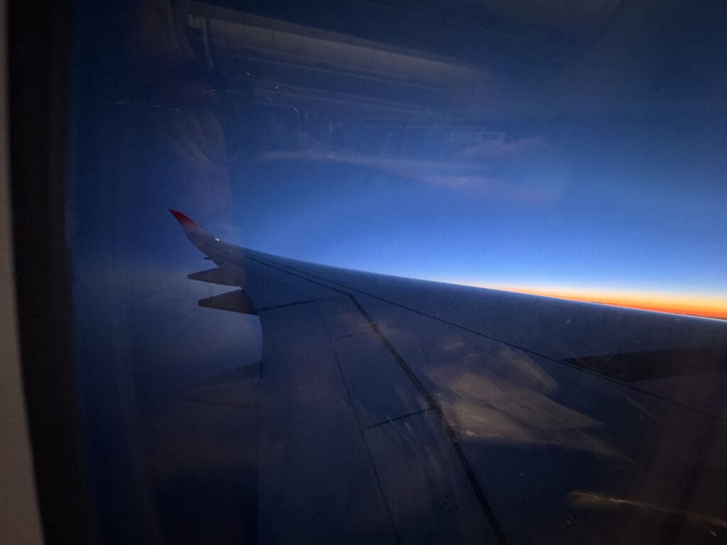 an airplane wing and blue sky