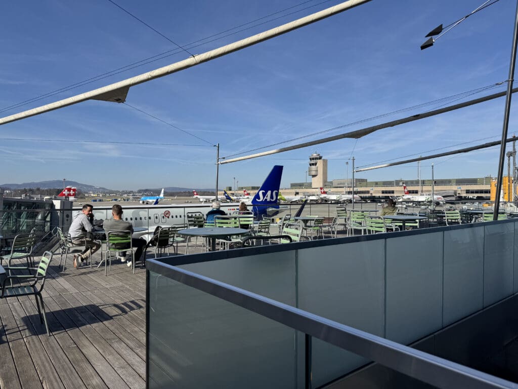 a group of people sitting at tables outside