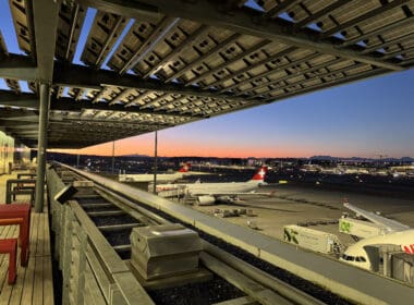 an airport with a train track and airplanes