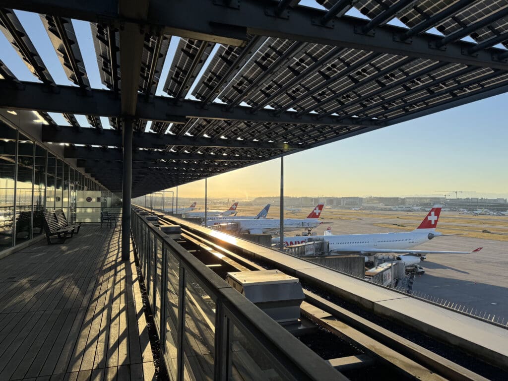 a metal structure with planes in the background