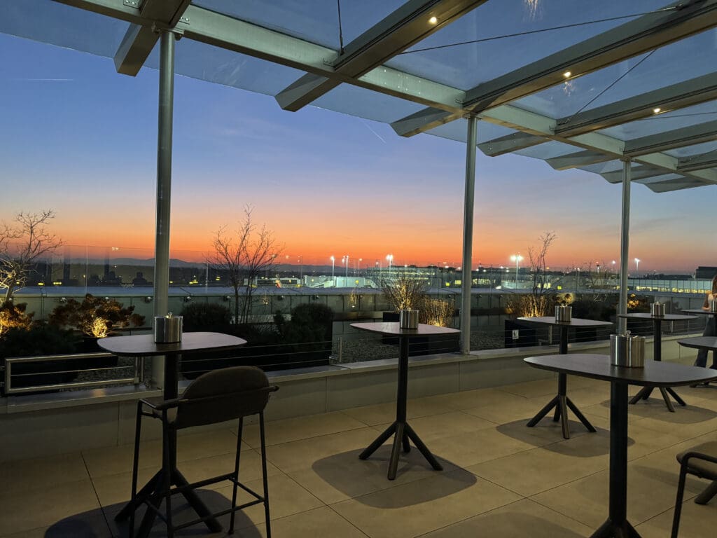 a glass roof with tables and chairs