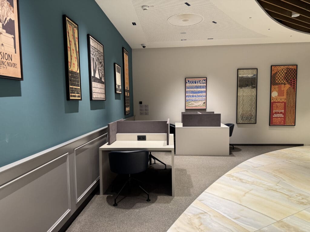 a room with a blue wall and a white desk and chairs