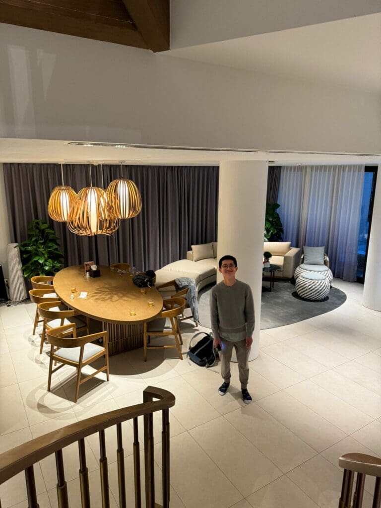 a man standing in a room with a table and chairs