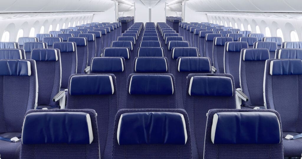 a rows of blue seats in an airplane
