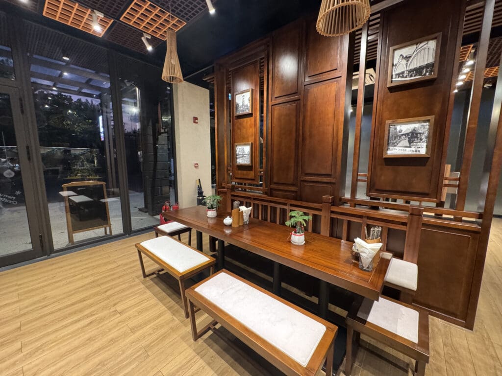 a table with benches and a couple of lamps from the ceiling