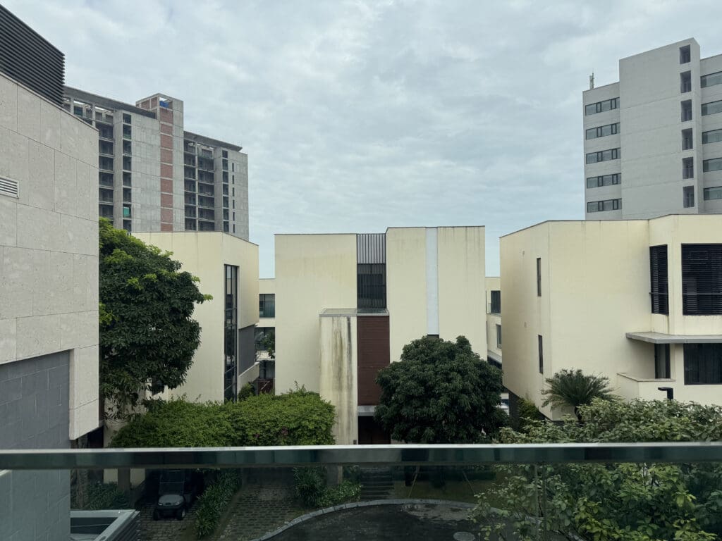 a group of buildings with trees and a glass railing