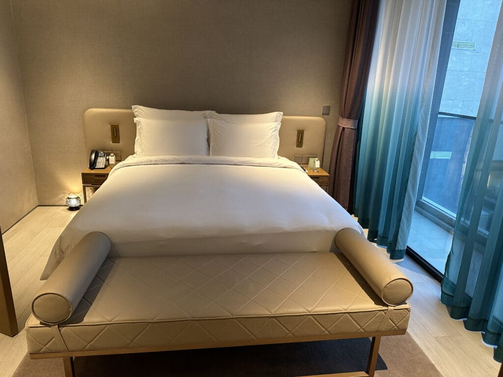 a bed with pillows and a couch in a room with a glass door