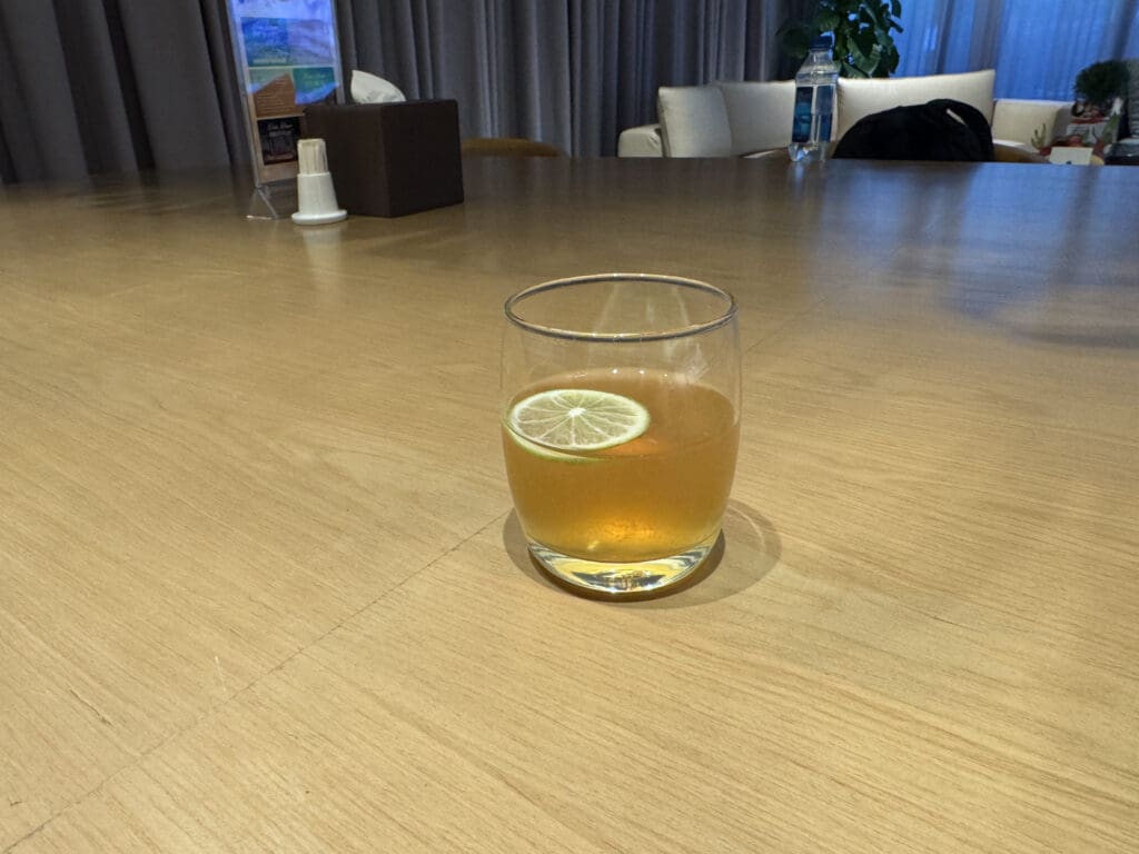 a glass of liquid with a lemon on a table