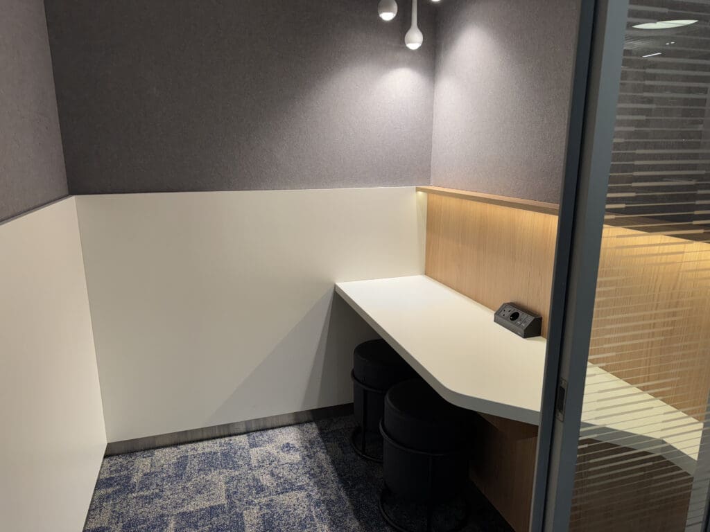 a white desk with black stools and a blue carpet