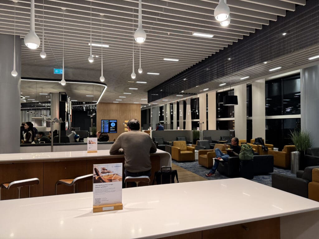 people sitting at a counter in a room with a large ceiling