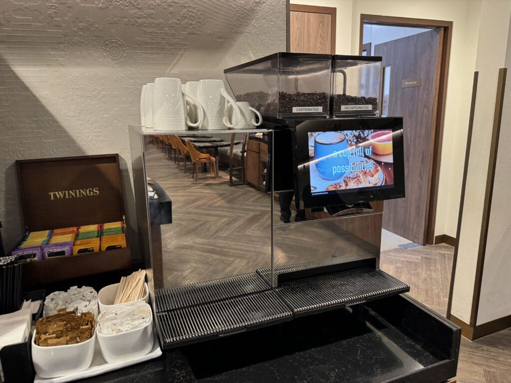 a coffee machine with a screen and cups on it