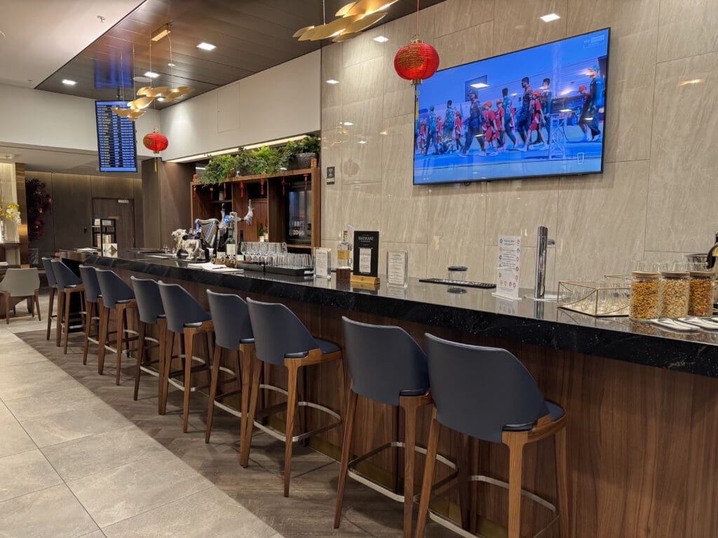 a bar with chairs and a television on the wall