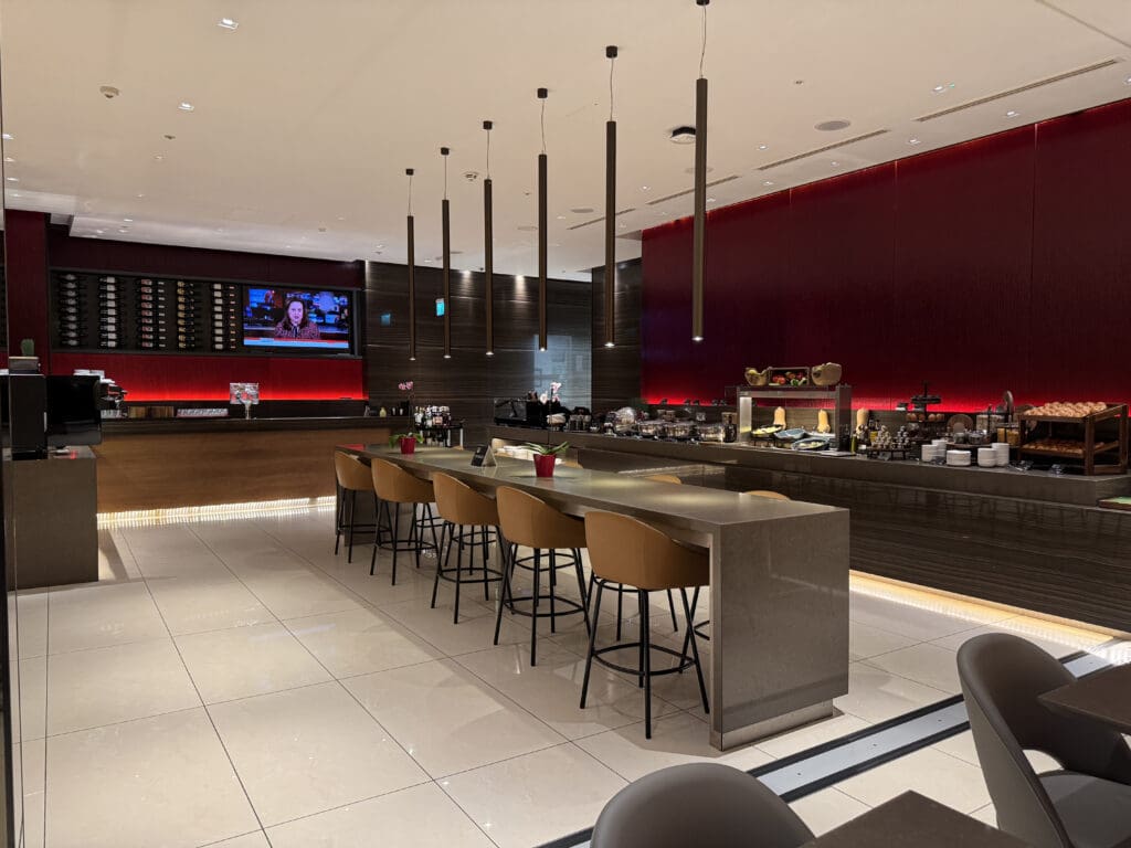 a long counter with chairs in a room with a tv and a bar