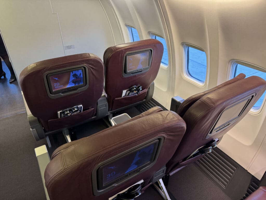 seats in an airplane with a screen on the back