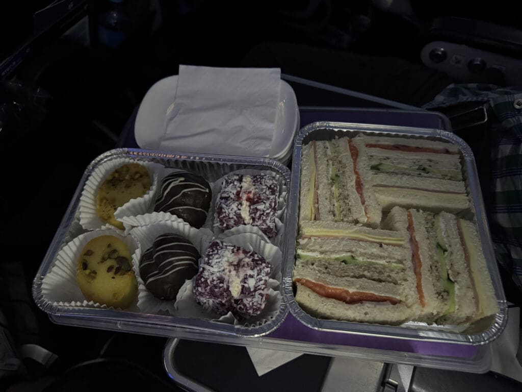 a tray of sandwiches and pastries