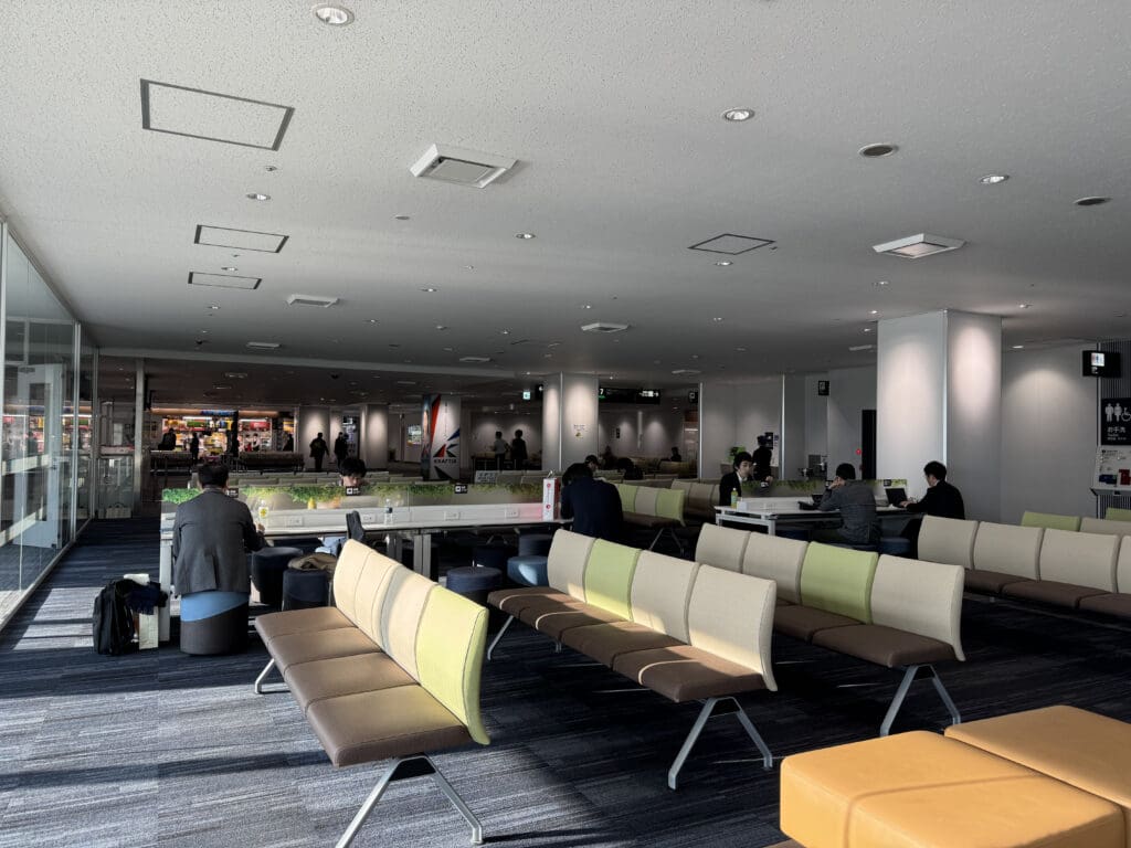 a group of people sitting in a room with benches